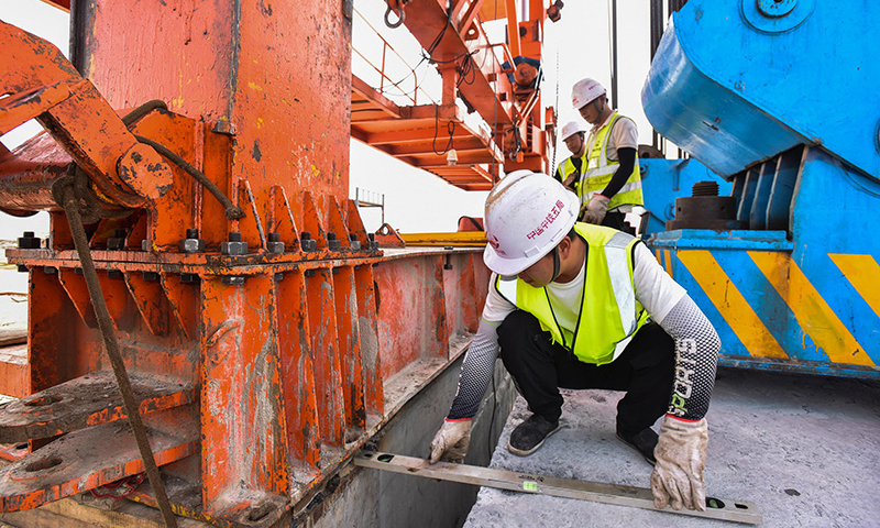 10月25日，施工人員在增江特大橋架梁現場輔助架橋機調整精度。新華社記者 劉大偉 攝