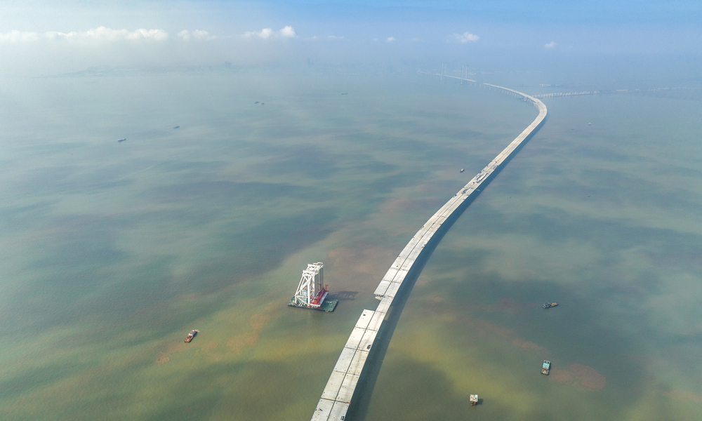 深中通道是集“橋、島、隧、水下互通”于一體的跨海集群工程，全長約24公里。其中海上非通航孔橋共設293片混凝土梁和鋼箱梁。梁體種類多，噸位重，架設精度要求高。本次架設混凝土梁單片長60米、寬20米、高3.5米，重約2800噸，相當于1800輛小轎車的重量，梁體頂部面積相當于3個標準籃球場。圖為11月10日拍攝的深中通道施工現場。