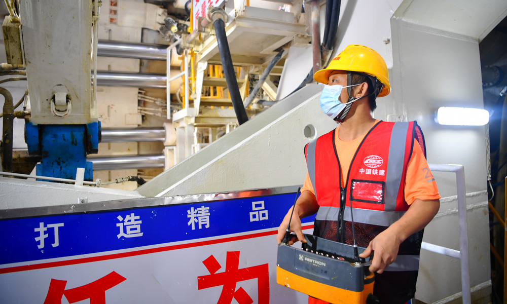 全長9640米的湛江灣海底隧道設計為單洞雙線，是全線唯一采用盾構施工法的隧道，其中7551米盾構區間由一臺開挖直徑14.33米的盾構機完成施工，是我國目前獨頭掘進距離最長的大直徑穿海高鐵盾構隧道。圖為盾構建設者正在拼裝管片。