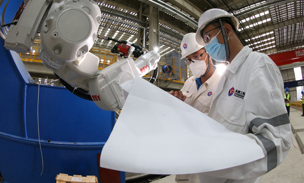 在后續工序中，為了充分利用好現有資源，項目組開始著手提高項目一體化率。依據涂裝車間的空間容積，項目團隊在生活樓建造中創新采用“六層三段”一體化建造方法，從而大大減輕了油漆破損和高空作業的風險，總裝工效大幅提升。圖為現場工程師對智能焊接機器人進行調試工作。