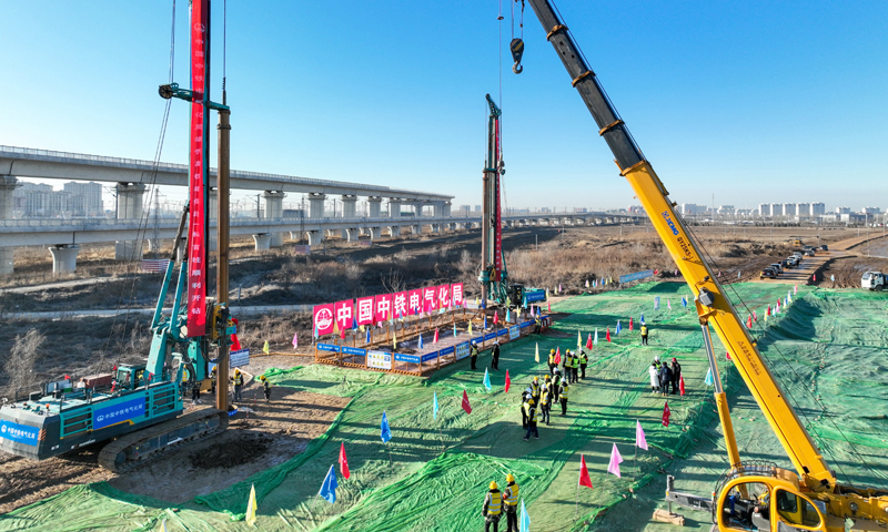 雄忻高鐵是我國“八縱八橫”高速鐵路網京昆通道的重要組成部分，線路東起京雄城際鐵路雄安站，西至大西高鐵忻州西站，正線全長342公里，設計時速350公里。圖為2月25日，中鐵電氣化局的施工人員在雄忻高鐵新蓋房特大橋建設現場施工（無人機照片）。新華社記者 牟宇 攝