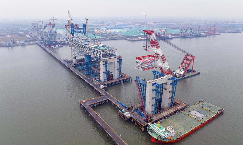 3月20日，常泰長江大橋主航道橋泰州側首節段鋼桁梁成功架設，標志著常泰長江大橋主航道橋鋼桁梁架設工作全面展開。圖為中交二航局建設者在常泰長江大橋主航道橋泰州側施工現場進行首節段鋼桁梁架設（無人機照片）。新華社發（湯德宏 攝）