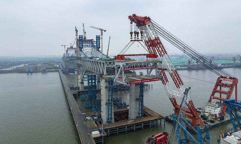 3月20日，中交二航局建設者在常泰長江大橋主航道橋泰州側施工現場進行首節段鋼桁梁架設（無人機照片）。新華社發（湯德宏 攝）