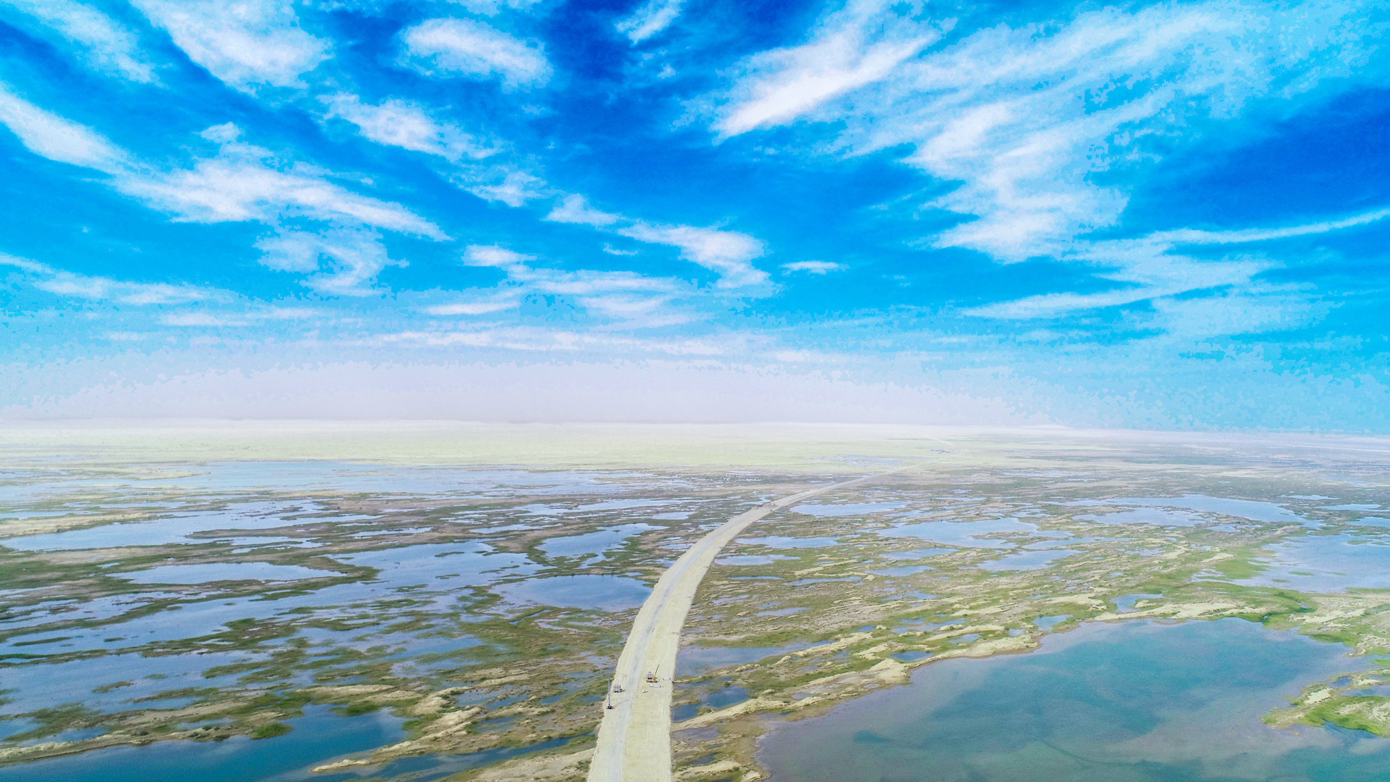 近年來，中國交建踐行綠色低碳發展理念，建設綠色工程，守護綠水青山。為保護野生動物的“樂園”——臺特瑪湖，中國交建總承包分公司新疆烏尉高速公路項目從設計源頭入手，繞道80公里外填筑路基，并為機械和車輛安裝托油盤，最大限度減少對湖區環境的影響，用實際行動加強生態環境保護。圖為項目施工現場。