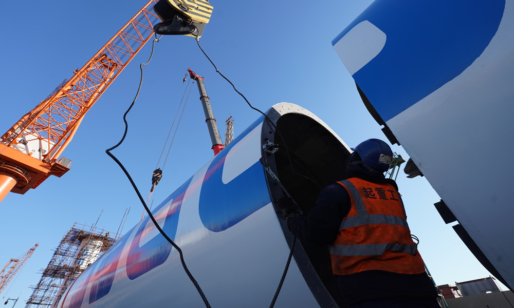 工作人員為船用風力旋筒助推系統塔筒的組裝掛載吊裝鎖具。杜春水 攝