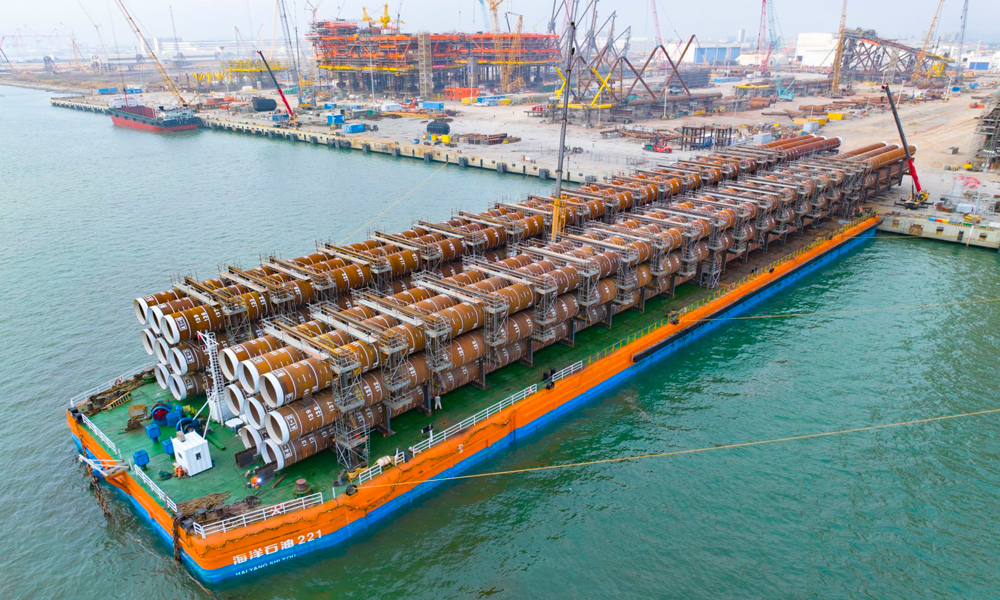 此次裝船作業采用SPMT（自行模塊運輸車）滾裝方式，刷新“海洋石油221”船單側裝船重量紀錄。面對船舶調載、承重極限、潮水周期受限等挑戰，項目團隊反復優化作業方案，密切關注船舶與潮水狀況，全力確保裝船作業安全順利。圖為“海基二號”導管架鋼樁完成裝船。