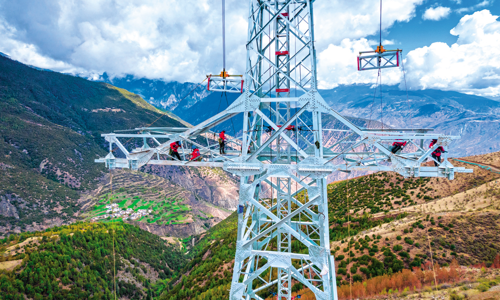 “西電東送”大動脈為經濟社會發展夯基，“沙戈荒”大型風電光伏基地外送工程為產業發展聚力，農村電網持續鞏固提升為改善農牧民生活托底……國家電網有限公司積極服務新時代西部大開發，加快推動電網轉型發展，為進一步形成大保護、大開放、高質量發展新格局作出國網貢獻。圖為國家電網西藏電力施工人員在±800千伏金上—湖北特高壓直流輸電工程線路工程（藏1標）開展組塔作業。