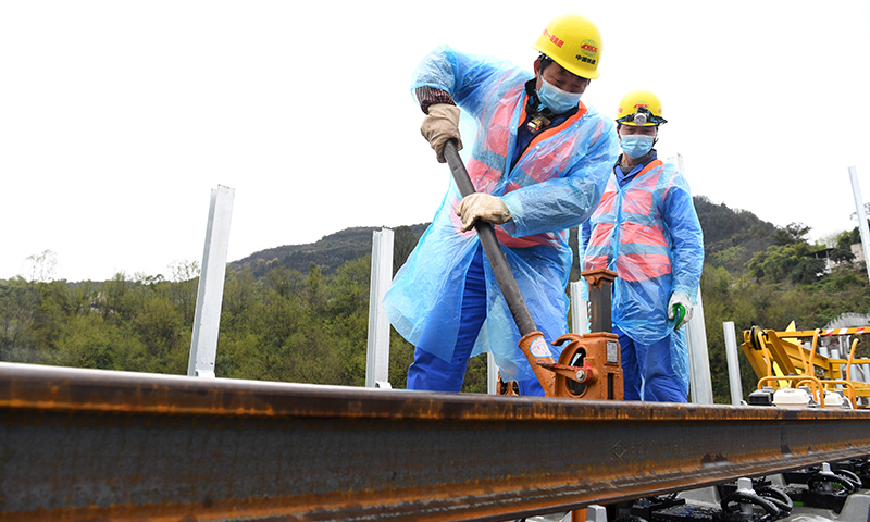 圖為3月1日，在鄭萬高鐵重慶段施工現場，施工人員進行鋪軌作業。(新華社記者 唐奕 攝)
