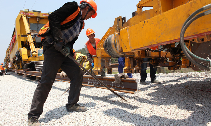 目前，中老鐵路國內段鐵軌鋪設施工正忙，在云南省西雙版納傣族自治州景洪市大渡崗鄉大荒壩村，承擔鋪軌任務的中鐵一局工人晝夜施工，加緊向前推進。圖為4月24日，工人在景洪市大渡崗鄉大荒壩段進行鋪軌作業。新華社發（李云生 攝）