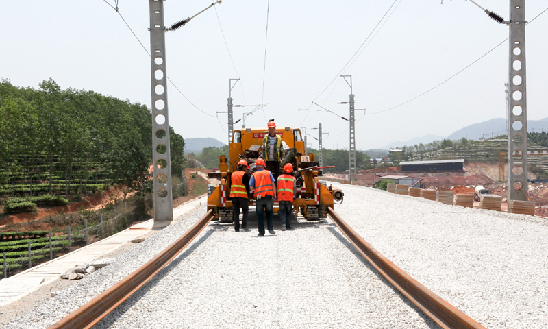 圖為4月24日，工人在景洪市大渡崗鄉大荒壩段操作機械牽引鐵軌。新華社發（李云生 攝）