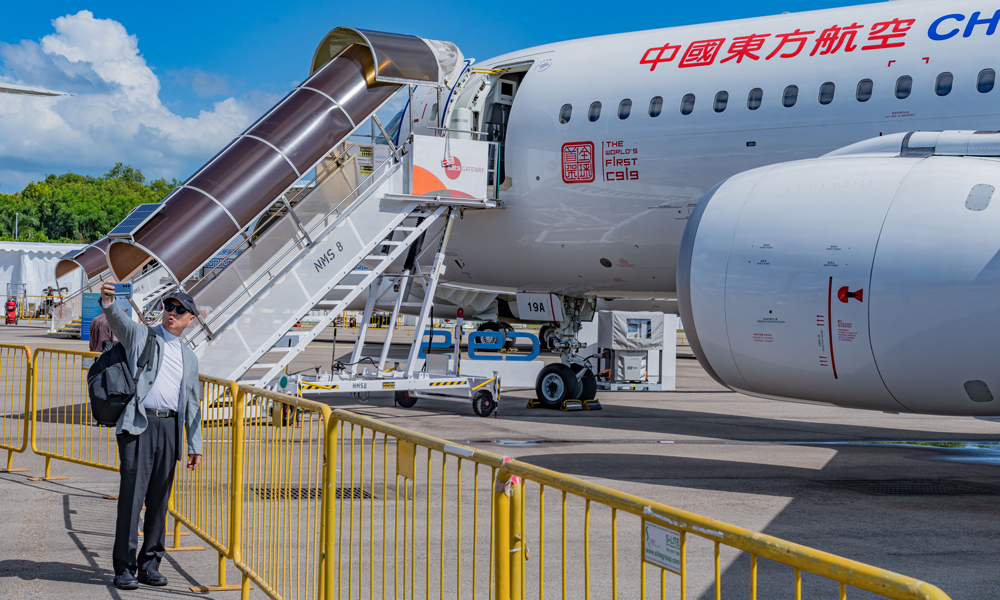 在為期6天的新加坡航展中，中國東航每個專業觀眾日接待團體觀眾超過20批。其中登機參觀者還有來自飛機制造商、航空服務提供商以及航空產業鏈上下游企業的負責人和資深專業人士。圖為參觀者與C919合影。