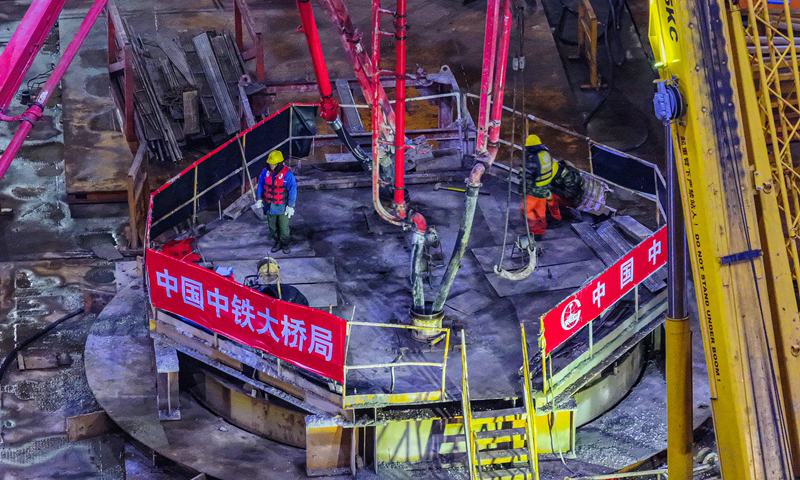 1月7日，位于浙江省舟山市的甬舟鐵路西堠門公鐵兩用大橋5號主墩超大直徑鉆孔樁灌注施工全部完成，大橋建設迎來階段性勝利。據了解，西堠門公鐵兩用大橋5號主墩由18根直徑6.3米鉆孔灌注樁組成。西堠門公鐵兩用大橋全長3118米，主橋主跨達1488米。圖為當日清晨，甬舟鐵路西堠門公鐵兩用大橋5號主墩超大直徑鉆孔樁灌注施工現場，工人在澆筑最后一根鉆孔樁（無人機照片）。新華社發（姚峰?攝）
