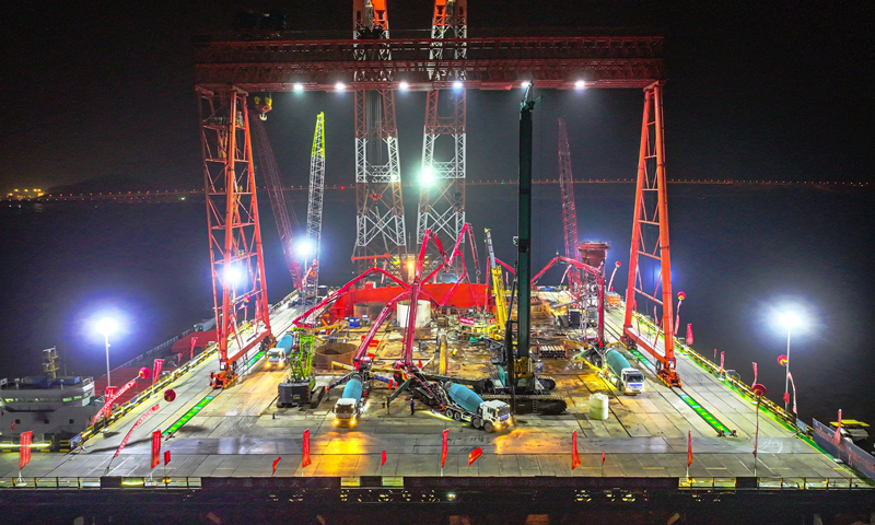 1月7日清晨，甬舟鐵路西堠門公鐵兩用大橋5號主墩超大直徑鉆孔樁灌注施工現場，工人在澆筑最后一根鉆孔樁（無人機照片）。新華社發（姚峰?攝）