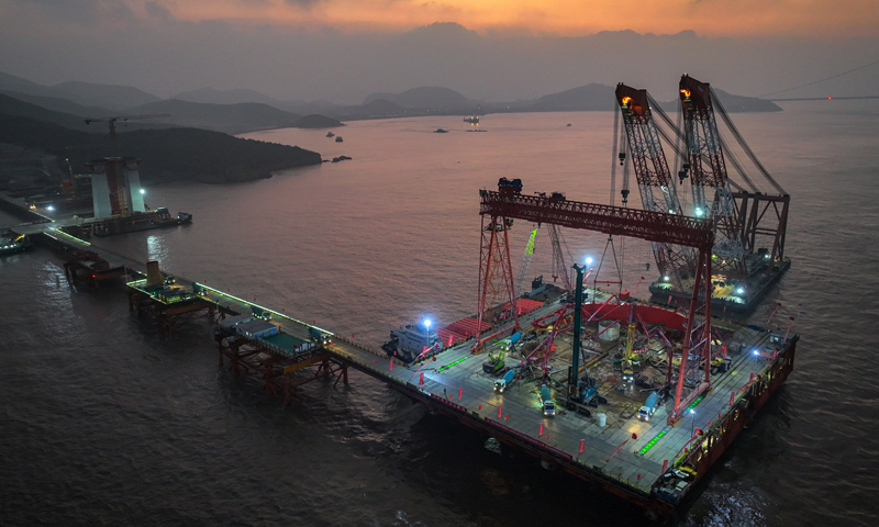 1月7日清晨，甬舟鐵路西堠門公鐵兩用大橋5號主墩超大直徑鉆孔樁灌注施工現場，工人在澆筑最后一根鉆孔樁（無人機照片）。新華社發（姚峰?攝）