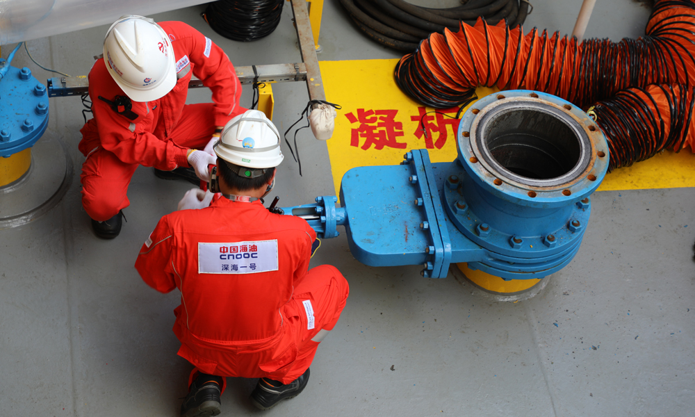 此前，“深海一號”能源站順利完成投產以來首次凝析油艙清艙檢測作業，檢測結果表明艙室運行狀態良好，能源站設計契合深海油氣開發實際需求，充分驗證了我國首創的深水半潛式儲卸油生產平臺設計的可靠性和先進性。圖為“深海一號”現場作業人員打開凝析油艙移動泵接入管線閘閥。周宇 攝