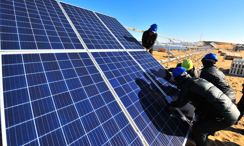 圖為工作人員安裝光伏板。