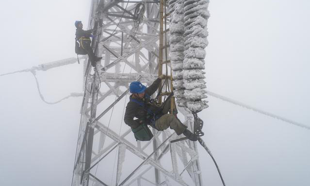 2月12日，受雨雪冰凍天氣影響，國網湖北省電力公司一供電線路出現故障，導致京廣高鐵橫店東至孝感北區段供電能力不足，造成途經該區段旅客列車不同程度晚點。故障發生后，國網武漢供電公司組織人員全力進行搶修。圖為搶修現場。（新華社記者 肖藝九 攝）
