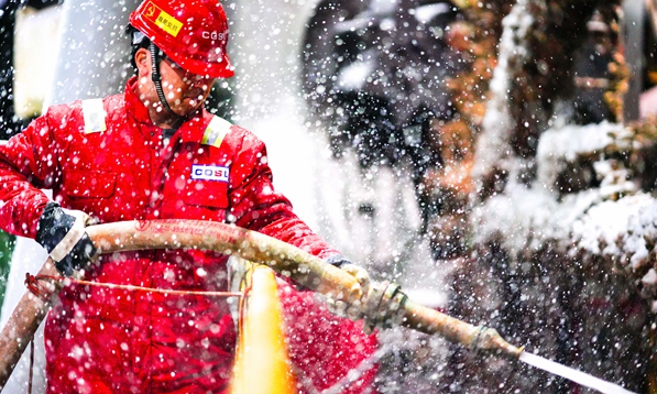 2月14日，正在拖航作業的“海洋石油923”鉆井平臺迎來降雪。為保障作業安全平穩進行，現場工作人員頂風冒雪堅守崗位。圖為平臺高級隊長劉海鵬在零下12℃的氣溫下完成該鉆井平臺樁靴及樁腿的淤泥清理工作。