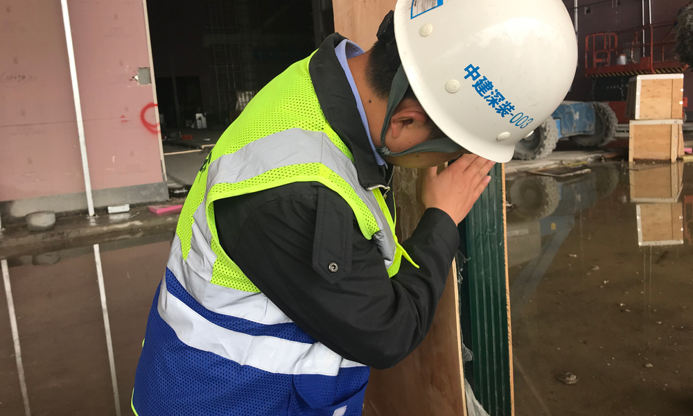 如何使動態變化的玻璃幕墻保持穩定？該項目技術總工陳欣友介紹，玻璃肋采用5層玻璃夾膠，總厚度達84毫米，高度達9米，頂部滑移構件可吸收主體結構最大300mm滑動。為防止熱脹冷縮導致玻璃破裂，玻璃銜接處都留有縫隙，在后期以密封膠加固防止漏風，并可承受面板荷載。圖為中建裝飾幕墻項目工作人員講解玻璃幕墻穩定技術原理。（國務院國資委網站 李子紅 攝）