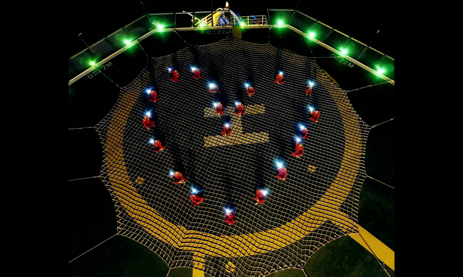 圖為5月24日夜，“南海二號”開展“海上職工小家”主題活動，員工們在直升飛機坪用手機燈光組成心形圖案，給遠方的家人送去思念與祝福（無人機拍攝）。（新華社記者 王毓國 攝）