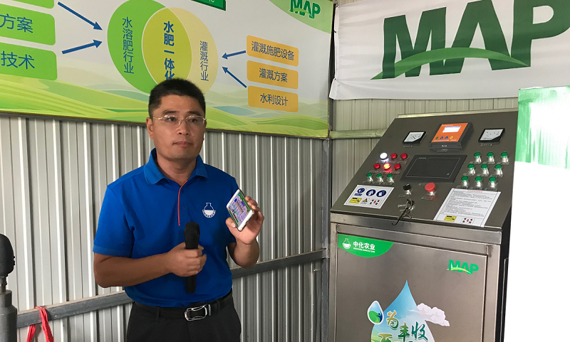 圖為位于示范農場旁的智能配肥站控制設備，中化農業水肥一體化技術總監王寶杰在進行設備演示。王寶杰告訴記者，液體水溶肥和水一塊進入試驗田中可以使肥料的利用率達到90%以上。（國務院國資委網站 宋詞 攝）