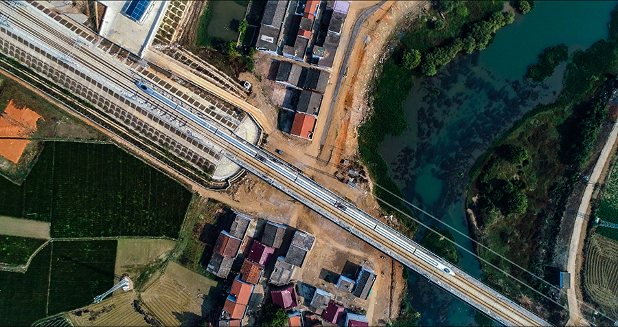 互聯互通，精準扶貧，昌贛高鐵是一條金色發展之路。從“軍旗升起的地方”英雄城南昌出發，昌贛高鐵跋山涉水，經過吉安、興國、萬安等革命老區；肩負振興老區、脫貧攻堅的使命，昌贛高鐵將“將軍縣”接入全國高鐵網。它既是京港高鐵的重要組成部分和先期實施段，同時又是江西省以南昌為中心“十”字快速鐵路網的重要組成部分。圖為昌贛高鐵通車運營。