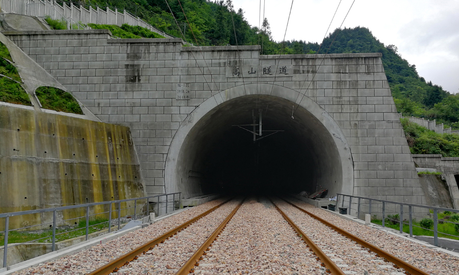 在全長3958米的高山隧道施工中，中國鐵建建設者采用平導迂回繞行等措施，取得了《穿越巨型溶洞的回填技術和施工方法》等10多項技術；以標準化管理為核心，采用“多站點”管理模式，咸豐站、來鳳站、龍山北站和桑植站4個站房在全線成為精品和樣板。圖為中鐵十四局承建的黔張常鐵路高山隧道。（李楊 攝）