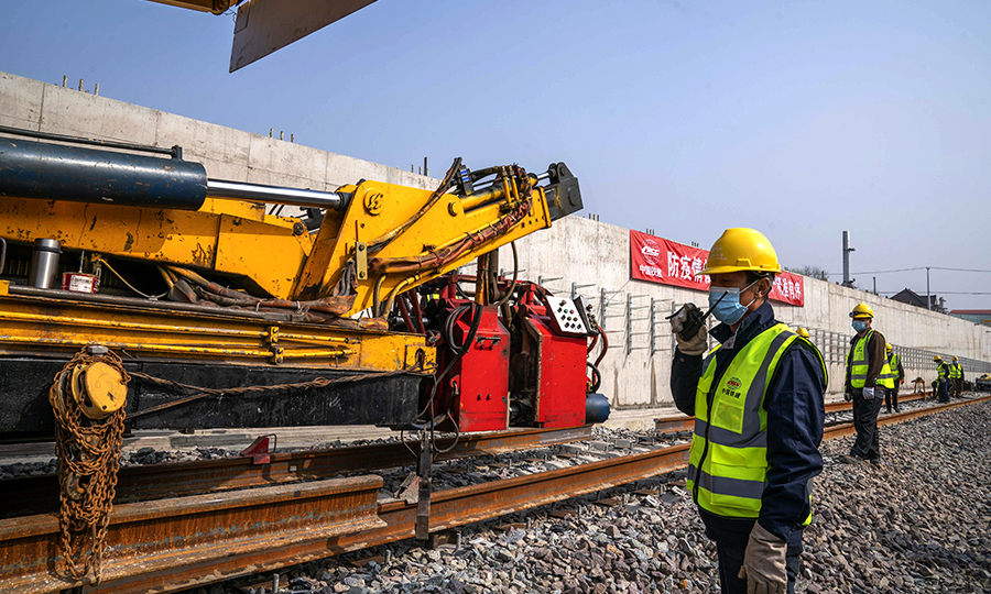 為確保疫情防控和復工復產穩步推進，中國鐵建所屬中鐵二十四局上海地鐵15號線項目部強化施工現場科學管理，優化施工工序，錯峰、分工點、分區段進行施工生產，要求施工現場做到“四必須”：入場必須測體溫、必須戴口罩、必須實名登記、工前所有器具和機械必須消毒。圖為上海地鐵15號線鋪軌B標工人師傅正在焊軌對位作業指揮。