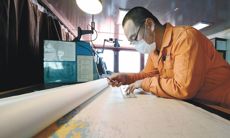 方圓幾公里的船舶和平臺共同鳴笛，45歲船齡、已在陸豐油田服役27年的浮式儲油輪（FSOU）“南海盛開”號解脫單點，緩緩啟動。陸豐13-2平臺上，多年來與“南海盛開”號船員遙相呼應的平臺員工齊聚直升機甲板，目送這位功勛“老將”一路壯歌、漸漸駛離。圖為出航前，二副于海峰繪制航線圖。