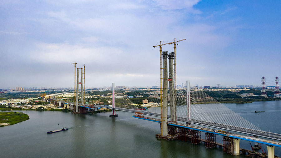 日前，由中國鐵建所屬中鐵十一局承建的粵港澳大灣區重點工程——廣州南沙港鐵路跨西江斜拉橋 156 號主塔順利封頂。至此，該橋兩座主塔全部封頂，正加快進行上部結構施工。圖為建設中的南沙港鐵路跨西江斜拉橋。（金偉 攝）