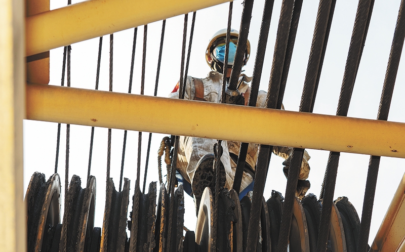 一名施工人員正在沿著臂桿走向檢修點。