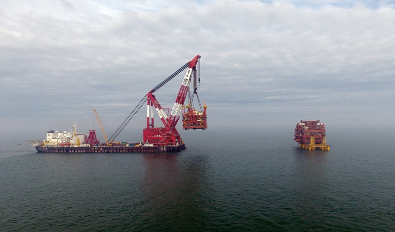 午后時分，轟鳴的馬達劃破寧靜的天空，“藍鯨”起重船精準發力，將“海洋石油221”船上重達4520噸的旅大16-3CEPA平臺西組塊平穩吊起，緩緩穿過平臺南北井口區，落至導管架設計位置。高效的海上施工作業，為全力打好應對低油價挑戰攻堅戰注入一針“強心劑”。圖為5月9日，渤海油田旅大16-3CEPA西組塊海上吊裝作業。