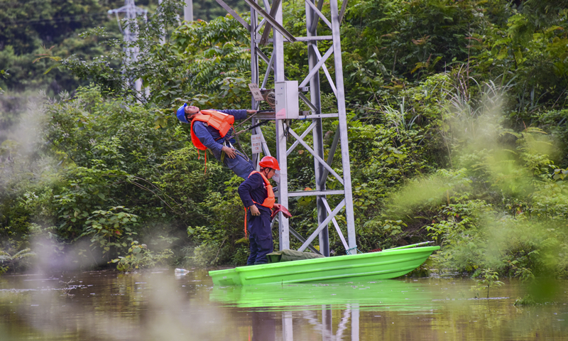 圖為6月6日，由于水勢持續上漲，南方電網廣西河池羅城供電局立即對受災線路進行隔離。（余菲 攝） 