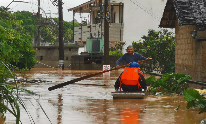 6月7日，在桂林荔浦市雙江鎮，災區群眾積極配合電力搶修人員開展搶險救援行動。（覃日友 攝）