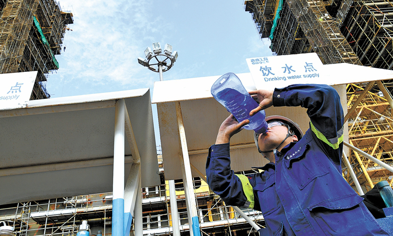 陵水17-2半潛平臺船體重約35000噸，由“回”字形浮箱和四個立柱組成，共計82個分段。這些分段在青島和煙臺建造完成后，最終集中到青島場地進行總裝搭載。圖為在悶熱的船艙里作業后，施工人員大量補充水分。