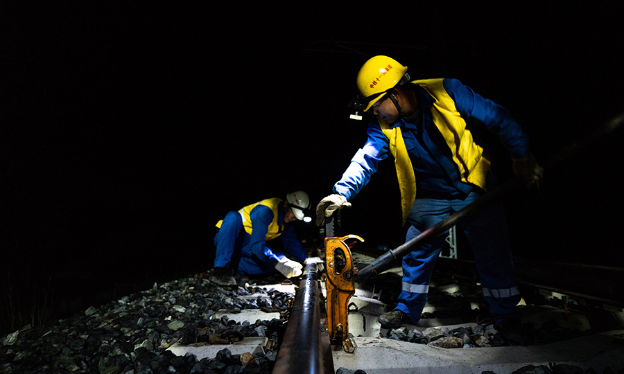 圖為施工人員正在調整鋼軌高度。（丁慶濱 攝）