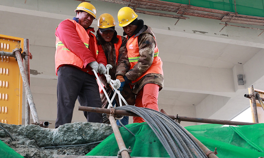 中鐵二十二局集團施工團隊還聯合哈爾濱工業大學成立了科技課題研發小組，針對極不平衡轉體施工控制技術、超低溫環境轉體關鍵技術、基于北斗衛星預警系統的復雜轉體信息化控制技術、基于BIM的跨鐵路站場狹小施工場地施工組織及安全管理等方面開展研究攻關。圖為專職人員整理轉體牽引鋼束。