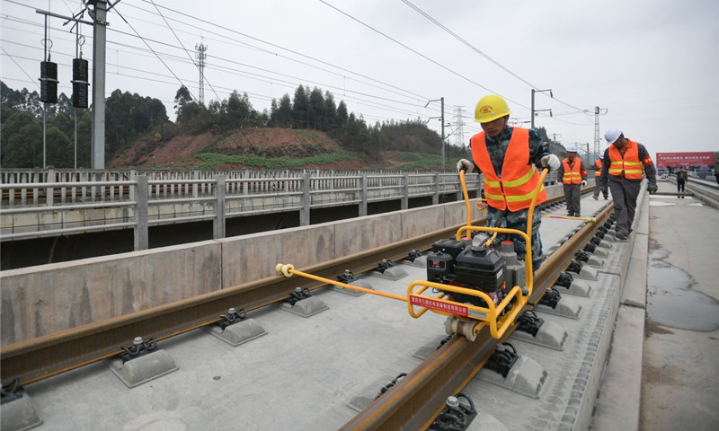 中鐵四局的建設者在四川省樂山市境內進行鋪軌作業。（新華社記者 薛玉斌 攝）