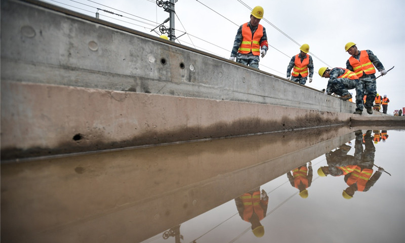 中鐵四局的建設者在四川省樂山市境內進行鋪軌作業。（新華社記者 薛玉斌 攝）