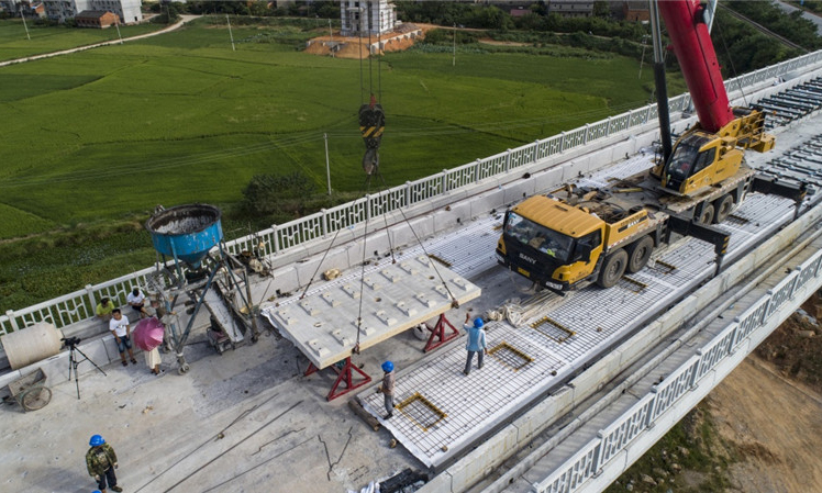 昌贛高鐵是京九高鐵的重要組成部分，總長約415.2公里，設計行車速度為350公里/小時。圖為8月30日，中鐵十一局職工在江西省豐城市境內的昌贛高鐵孫渡特大橋上吊裝無砟軌道板。（新華社記者 杜華舉 攝）