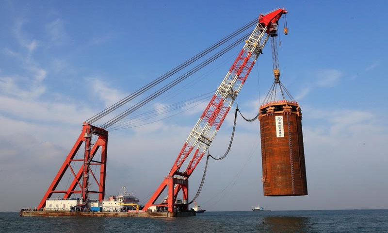 港珠澳大橋通車在即。從2009年12月15日，港珠澳大橋正式開工建設，到2018年2月，港珠澳大橋主體工程通過交工驗收，具備通車試運營條件，9年間，潮起潮落、寒來暑往，數以萬計的建設者在伶仃洋上造橋，在大海深處“穿針”，構筑起全長55公里的世界級跨海通道。圖為2011年9月11日，港珠澳大橋島隧工程西人工島最后一個鋼圓筒振沉成功，西人工島順利成島。新華社發（港珠澳大橋局提供）