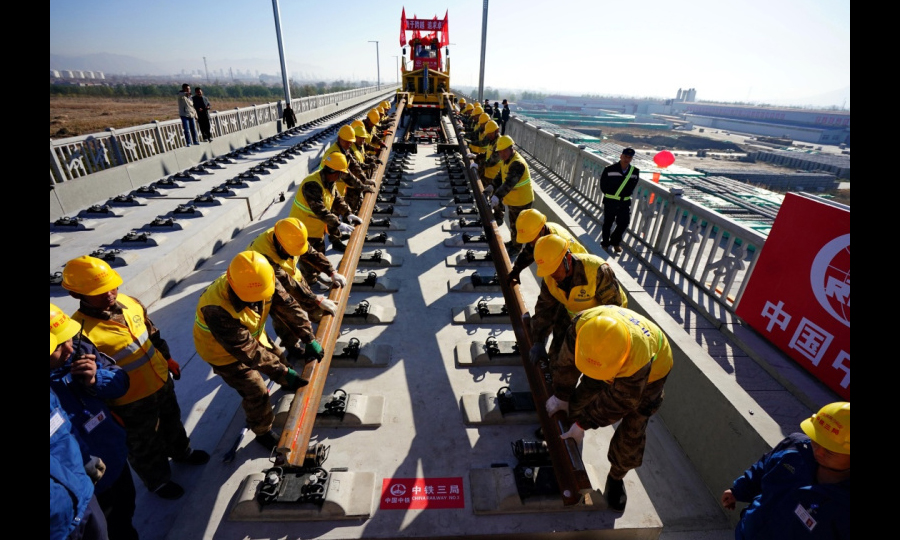 京張高鐵是國家重點建設項目，是2022年北京冬奧會的重要交通保障線。京張高鐵全長174公里，建成后，乘高鐵從北京到張家口的時間將縮短到50分鐘，對于助力奧運、促進京津冀一體化發展、連接西部都具有十分重要的戰略意義。圖為11月1日，在京張高鐵河北懷來段鋪軌現場，中鐵三局的工人鋪下京張高鐵全線第一節軌排。（新華社記者 楊世堯 攝）