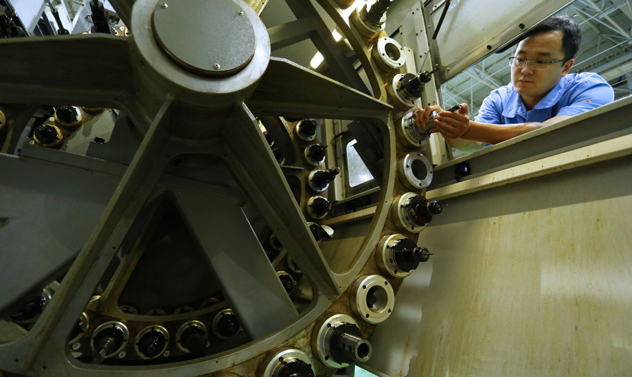 孫長勝在檢查刀庫里刀具的磨損的情況，上百把刀具，每次加工完都要仔細檢查一遍。（作者：封曉東）