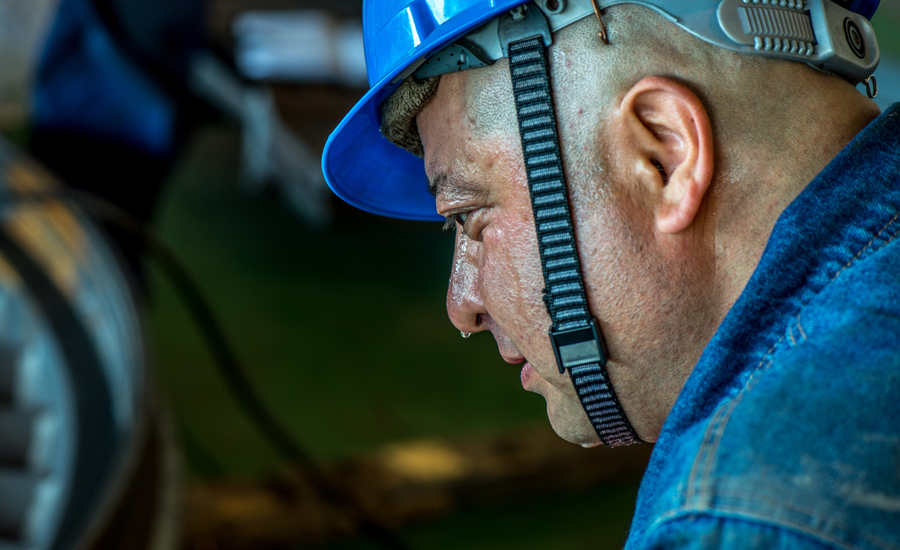 紅雁池電廠#3機組小修現場，一名焊工剛剛取下面罩，鼻尖上的汗珠上映射出手里的面罩。（作者：甄新梅）