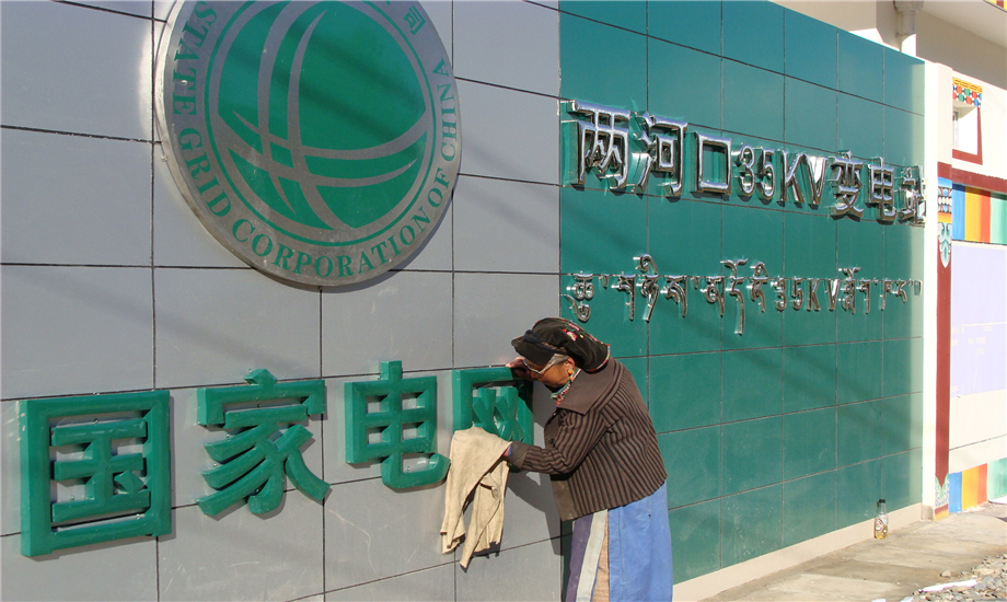 藏族老奶奶車朗漢姆特地從家里帶來清水抹布，仔細地擦拭國家電網標志。